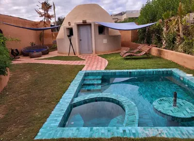 a small house with a swimming pool in the yard at Les Domes de l Ourika in Sidi Bouzguia