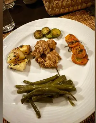a plate of food with vegetables on a table at Star Desert Camp Merzouga in Merzouga