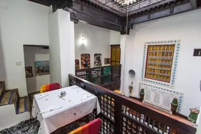 a balcony with a table and chairs and a ceiling at Casa Aya Medina in Fès