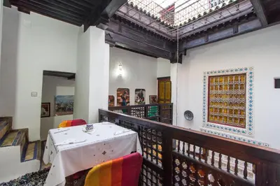 a balcony with a table and chairs and a skylight at Casa Aya Medina in Fès