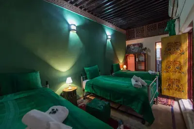 two green beds in a room with green walls at Casa Aya Medina in Fès