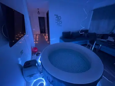 a bathroom with a tub in a room with a couch at Luxury Jacuzzi Apartment with Romantic Decoration in Fès
