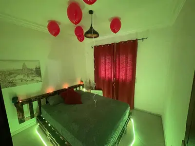 a bedroom with a bed with a red curtain and balloons at Luxury Jacuzzi Apartment with Romantic Decoration in Fès