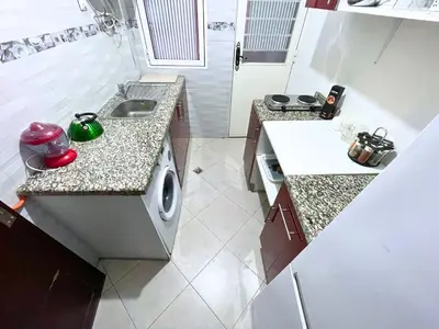 a small kitchen with a sink and a washing machine at Luxury Jacuzzi Apartment with Romantic Decoration in Fès