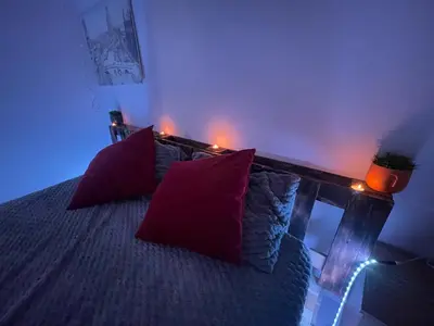 a bedroom with a bed with red pillows and lights at Luxury Jacuzzi Apartment with Romantic Decoration in Fès