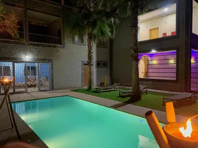 a swimming pool with a house with a purple garage at Villa Gomez in Sbiti