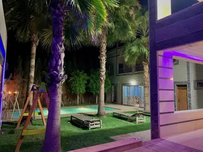 a backyard with a playground with palm trees and a pool at Villa Gomez in Sbiti