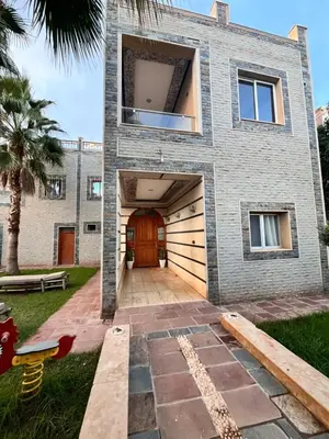 a brick house with a garage and a wooden door at Villa Gomez in Sbiti