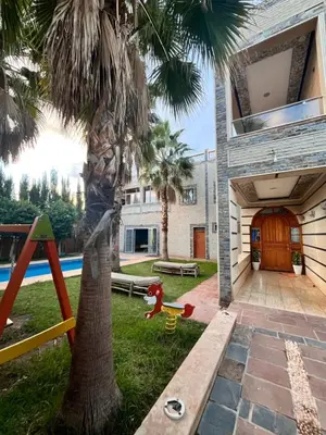 a house with a palm tree and a playground at Villa Gomez in Sbiti