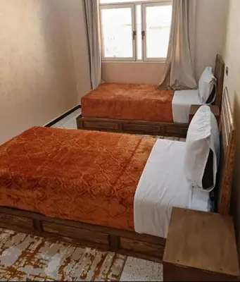 two beds in a room with a window at La Chambre d hote in Ouarzazate