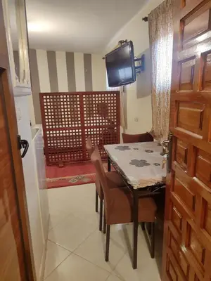 a dining room with a table and chairs and a television at Central Bonheur Studio in Midelt
