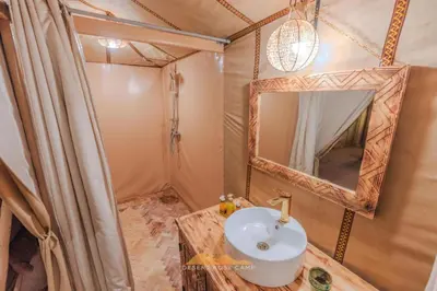 a bathroom with a sink and a mirror at Top Desert Camp in Merzouga