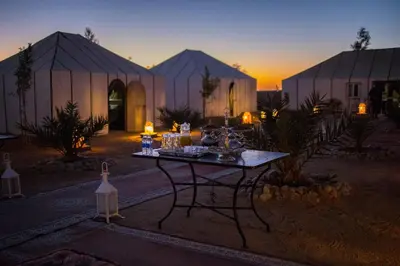 a table in front of a building at sunset at Top Desert Camp in Merzouga