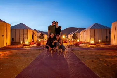 a group of people posing for a picture in front of buildings at Top Desert Camp in Merzouga