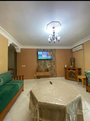 a living room with a green couch and a television at appartement luxe in Meknès