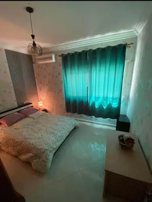 a bedroom with a bed and a blue curtain at appartement luxe in Meknès