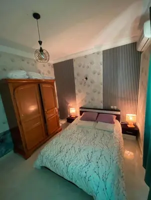 a bedroom with a bed with two lights on it at appartement luxe in Meknès