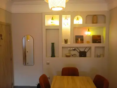 a dining room with a table and a mirror at Appartement moderne 2 chambres À 5 min de l'aéroport RAK avec Wi-Fi rapide in Oulad Akkou
