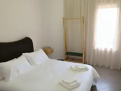 a bedroom with a white bed with two towels on it at Appartement moderne 2 chambres À 5 min de l'aéroport RAK avec Wi-Fi rapide in Oulad Akkou