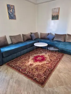 a blue couch with two tables in a living room at Appartement atlas fes 5 in Fès