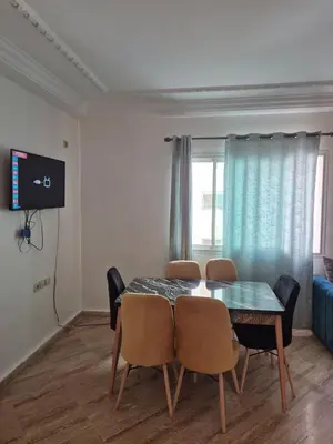 a dining room with a table and chairs and a television at Appartement atlas fes 5 in Fès