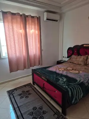 a bedroom with a bed and a window with pink curtains at Appartement atlas fes 5 in Fès