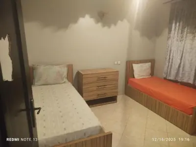 a bedroom with two beds and a wooden dresser at Otmania house Meknès in Meknès