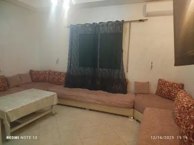 a living room with a couch and a window at Otmania house Meknès in Meknès