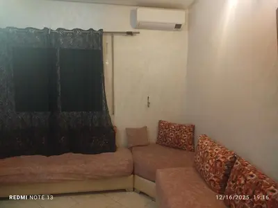 a living room with a couch and a window at Otmania house Meknès in Meknès