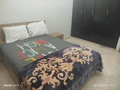 a bedroom with a bed with a comforter on it at Otmania house Meknès in Meknès