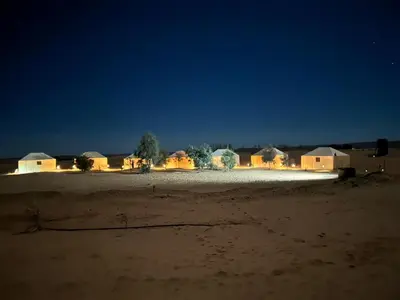 a group of lodges in the desert at night at Désert camp berbère Sahara in Merzouga