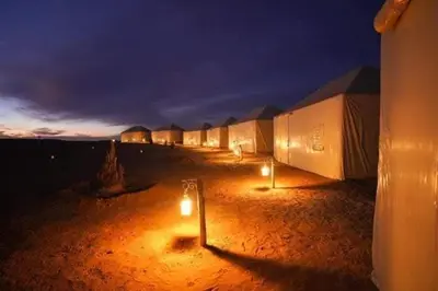 a row of tents in the desert at night at Désert camp berbère Sahara in Merzouga