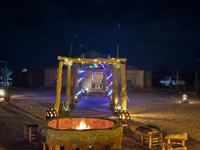 a wedding arch with lights on the beach at night at Désert camp berbère Sahara in Merzouga