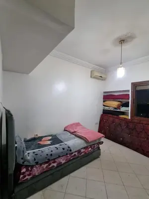a bedroom with a bed and a couch at 5 min from the field in Fès
