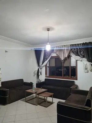 a living room with couches and a table and a window at 5 min from the field in Fès