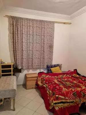 a bedroom with a red bed and a window at 5 min from the field in Fès
