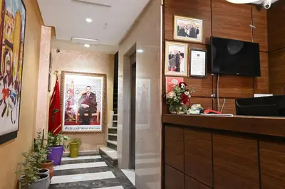 a lobby with a staircase and a television in a building at Hôtel Vallée Ziz in Er Rachidia