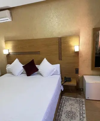 a bedroom with a large white bed with two pillows at Hôtel Vallée Ziz in Er Rachidia