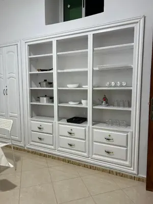 a white cabinet with drawers and dishes in it at Spacious Family Apartment in Er Rachidia