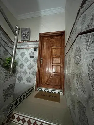 a staircase with a wooden door in a room at Spacious Family Apartment in Er Rachidia