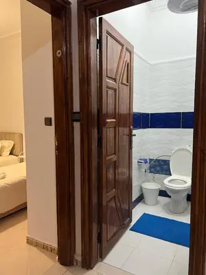 a bathroom with a toilet and a wooden door at Spacious Family Apartment in Er Rachidia