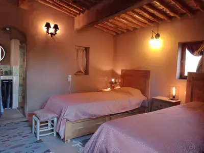 a bedroom with two beds and a window at Jnan Ksar el Kdim - Studios Safran, Jasmin et Cannelle in Mhamid