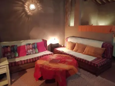 a living room with a couch and a table at Jnan Ksar el Kdim - Studios Safran, Jasmin et Cannelle in Mhamid