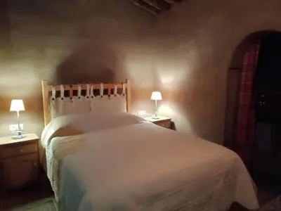 a bedroom with a large bed with two lamps on tables at Jnan Ksar el Kdim - Studios Safran, Jasmin et Cannelle in Mhamid