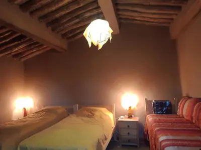 a bedroom with two beds and a chandelier at Jnan Ksar el Kdim - Studios Safran, Jasmin et Cannelle in Mhamid