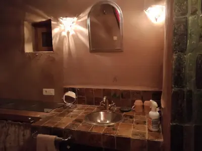 a bathroom with a sink and a mirror at Jnan Ksar el Kdim - Studios Safran, Jasmin et Cannelle in Mhamid