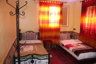a small room with two beds and curtains at La Belle étoile in Aït Oussane