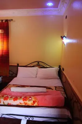 a bedroom with a bed with a red blanket on it at La Belle étoile in Aït Oussane