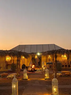 a building with lights in front of it at night at Fabulous Royal Camp in Merzouga