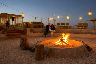 a fire pit with two people sitting around it at Star Dunes in Mhamid